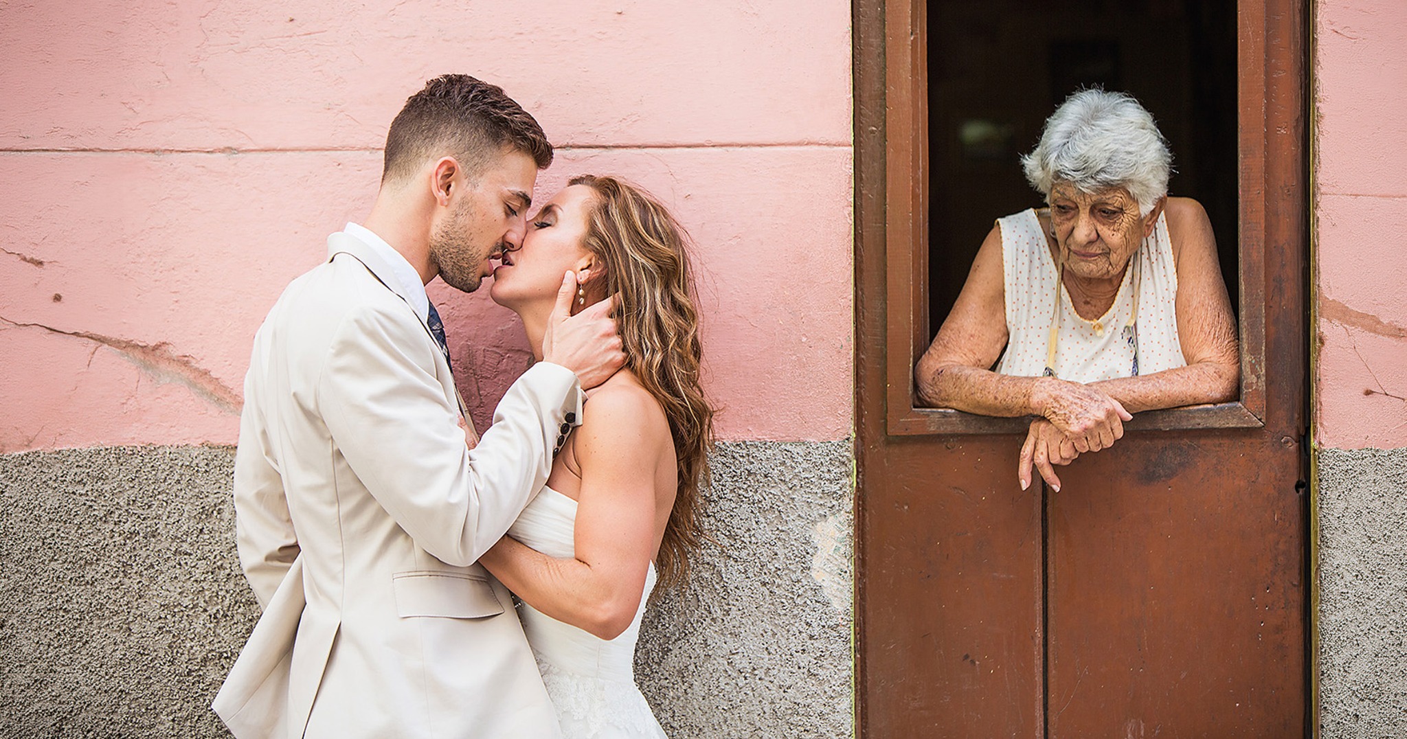 Jennifer and Markwell walking through a historic Cuban street with their wedding party