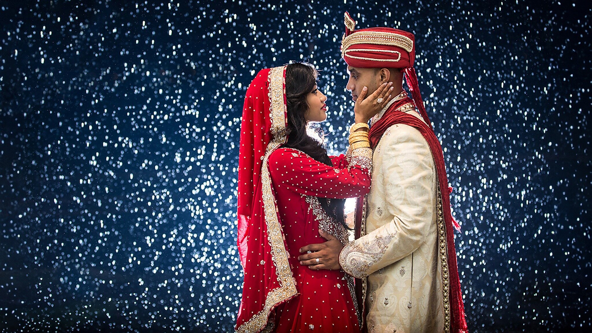 Couple embracing during a snowy nighttime wedding portrait session